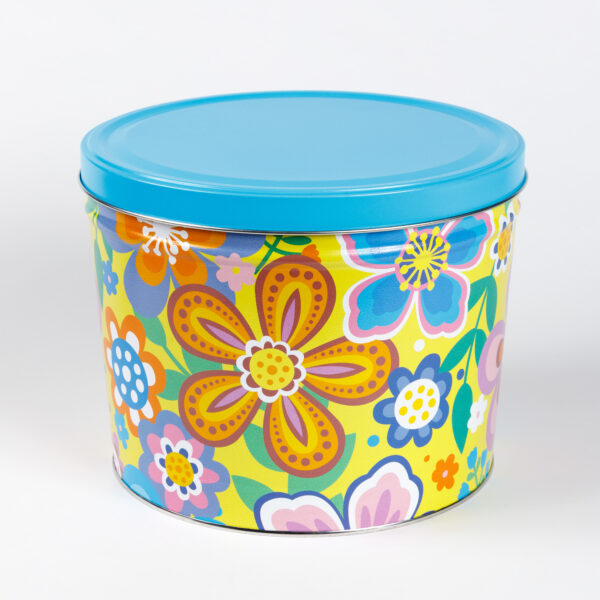 A metal gift tin with a bright floral pattern and a light blue metal lid.